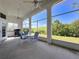 View of screened patio with tiled floor, ceiling fans, table and chairs with view of surrounding trees at 8606 Coral Creek Loop, Hudson, FL 34667