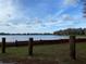 Lake view featuring a wooden fence along the shoreline, complemented by serene water and sky at 00 Purdue St, New Port Richey, FL 34654