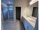 Primary bathroom featuring double vanities, quartz counters, and a glass-enclosed shower at 10012 Zennia Ln, Parrish, FL 34219