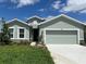 Charming single-Gathering home featuring a two-car garage, manicured lawn, and inviting curb appeal at 10012 Zennia Ln, Parrish, FL 34219
