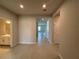 Open hallway view showcasing tile flooring, neutral paint, and a doorway leading to a bathroom at 10012 Zennia Ln, Parrish, FL 34219
