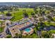 Aerial view showcases community building with a swimming pool, landscaping, and golf course in the background at 11050 Kiskadee Cir, New Port Richey, FL 34654