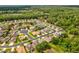 Overhead view of SummerTree homes nestled among trees, featuring landscaped yards and a pond in a tranquil setting at 11050 Kiskadee Cir, New Port Richey, FL 34654