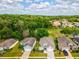 Homes with landscaped yards in the SummerTree community, adjacent to a lush green area with mature trees at 11050 Kiskadee Cir, New Port Richey, FL 34654