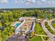 An aerial view showcases the community clubhouse with pool, parking, and lush green surroundings at 11050 Kiskadee Cir, New Port Richey, FL 34654