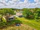 Green backyard featuring a screened-in porch and pond access, surrounded by mature trees in the SummerTree community at 11050 Kiskadee Cir, New Port Richey, FL 34654