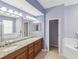 Lavish bathroom with double vanity, granite counters, and soaking tub at 11050 Kiskadee Cir, New Port Richey, FL 34654