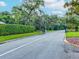 A gated entrance to the SummerTree community, surrounded by lush green foliage and mature trees at 11050 Kiskadee Cir, New Port Richey, FL 34654