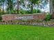 The SummerTree community sign with stone accents, landscaping, and lush green grass on a sunny day at 11050 Kiskadee Cir, New Port Richey, FL 34654