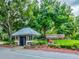 The SummerTree community guard house surrounded by lush landscaping, trees, and the community sign at 11050 Kiskadee Cir, New Port Richey, FL 34654