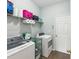 Well-organized laundry room with washer, dryer, storage shelves, and tile flooring at 11050 Kiskadee Cir, New Port Richey, FL 34654