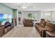 Spacious living room with neutral carpet, ceiling fan, and sliding glass doors to the lanai at 11050 Kiskadee Cir, New Port Richey, FL 34654