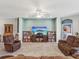 Inviting living room with comfortable seating, a ceiling fan, and a view into another room at 11050 Kiskadee Cir, New Port Richey, FL 34654