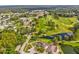 Panoramic aerial view of a golf course community with mature trees, ponds and rolling green fairways at 11524 Holly Ann Dr, New Port Richey, FL 34654