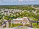 Aerial view captures a community building, pool, shuffleboard courts, and surrounding residences at 11524 Holly Ann Dr, New Port Richey, FL 34654