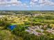 Aerial view of the property showcasing its location near a golf course, lake, and lush greenery at 11524 Holly Ann Dr, New Port Richey, FL 34654