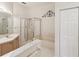 Well-lit bathroom showcasing a glass-enclosed shower, bathtub, and vanity with stylish fixtures at 11524 Holly Ann Dr, New Port Richey, FL 34654