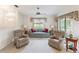 Comfortable living room featuring cozy seating, natural light, and a ceiling fan at 11524 Holly Ann Dr, New Port Richey, FL 34654