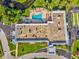 Aerial view of a community pool with lounge chairs, landscaping, and adjacent spa at 11524 Holly Ann Dr, New Port Richey, FL 34654