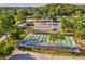Aerial view of well-maintained shuffleboard courts with covered seating and parking area at 11524 Holly Ann Dr, New Port Richey, FL 34654