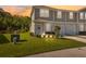 Charming townhome with well-manicured lawn and landscape is illuminated by the sunset and outdoor lighting at 12214 Grizzly Ln, New Port Richey, FL 34654