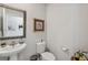 Well-lit half bathroom featuring a pedestal sink, toilet, and decorative accents at 12214 Grizzly Ln, New Port Richey, FL 34654