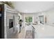 Bright kitchen featuring stainless steel appliances, white cabinets, and an island with a view to the backyard at 12214 Grizzly Ln, New Port Richey, FL 34654