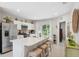 Well-lit kitchen with stainless steel appliances, white cabinets, and a spacious island with bar stools at 12214 Grizzly Ln, New Port Richey, FL 34654