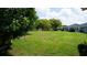 Expansive backyard with green lawn and mature trees, adjacent to neighboring homes at 12371 Dearborn Dr, Hudson, FL 34667