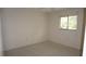 A cozy bedroom featuring neutral walls, carpet flooring, and a window for natural light at 12371 Dearborn Dr, Hudson, FL 34667