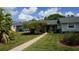 Charming home featuring a walkway leading to the entrance and lush, mature landscaping at 12371 Dearborn Dr, Hudson, FL 34667