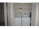 Laundry closet with washer, dryer, shelving, and folding doors for privacy at 12371 Dearborn Dr, Hudson, FL 34667