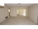 Spacious living room with carpet flooring and sliding glass doors leading to an enclosed porch at 12371 Dearborn Dr, Hudson, FL 34667