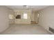 Open-concept living area with a kitchen view, neutral carpet, ceiling fan, and mirrored wall at 12371 Dearborn Dr, Hudson, FL 34667