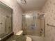 Well-lit bathroom featuring a shower/tub combo with sliding glass doors and floral wallpaper at 12541 Dearborn Dr # B, Hudson, FL 34667