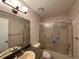 Well-lit bathroom featuring a shower/tub combo with sliding glass doors and floral wallpaper at 12541 Dearborn Dr # B, Hudson, FL 34667