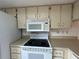 Well-lit kitchen featuring a white appliance suite and a functional layout for easy meal preparation and storage at 12541 Dearborn Dr # B, Hudson, FL 34667