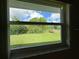 Window view of backyard with blue sky and green trees at 12541 Dearborn Dr # B, Hudson, FL 34667