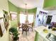 Breakfast nook with a chandelier, bright green walls, and natural light from the sliding glass doors at 13010 Siam Dr, Spring Hill, FL 34609