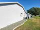 Side view of the home showing the exterior paint, landscaping, and gravel bed at 13010 Siam Dr, Spring Hill, FL 34609