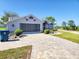 Lovely home featuring a screened-in garage, stone driveway and appealing landscaping at 13010 Siam Dr, Spring Hill, FL 34609