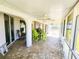 Relaxing screened patio with tile flooring, ceiling fans, and bright green outdoor dining set at 13010 Siam Dr, Spring Hill, FL 34609