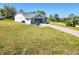 Beautiful home with large lawn and stone driveway leading to a screened-in garage at 13010 Siam Dr, Spring Hill, FL 34609