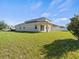 This property features a big green backyard with a white fence and a covered patio at 13366 Barkingside Pl, Spring Hill, FL 34609