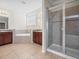 Bright bathroom featuring double sink vanity, a soaking tub, and a glass-enclosed shower at 13366 Barkingside Pl, Spring Hill, FL 34609