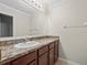 Bathroom with single sink, granite counters, cabinets, and a large mirror at 13366 Barkingside Pl, Spring Hill, FL 34609