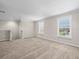 Bonus room featuring neutral carpet, base molding, and large windows with shades at 13366 Barkingside Pl, Spring Hill, FL 34609