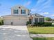 Charming two-story home with a three car garage, manicured lawn, and neutral stucco exterior at 13366 Barkingside Pl, Spring Hill, FL 34609