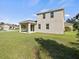 Exterior view of the home with a covered patio, large windows, and a lush green backyard at 13366 Barkingside Pl, Spring Hill, FL 34609