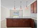 Kitchen island boasts pendant lighting, dark wood cabinetry, and granite countertops at 13366 Barkingside Pl, Spring Hill, FL 34609